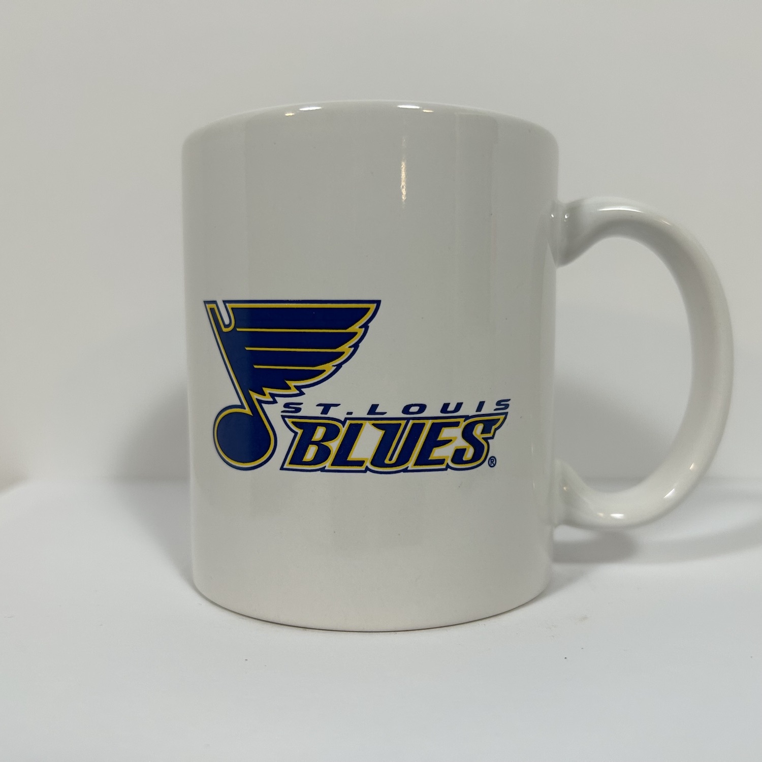 simple white coffee mug with the late two thousands blues logo