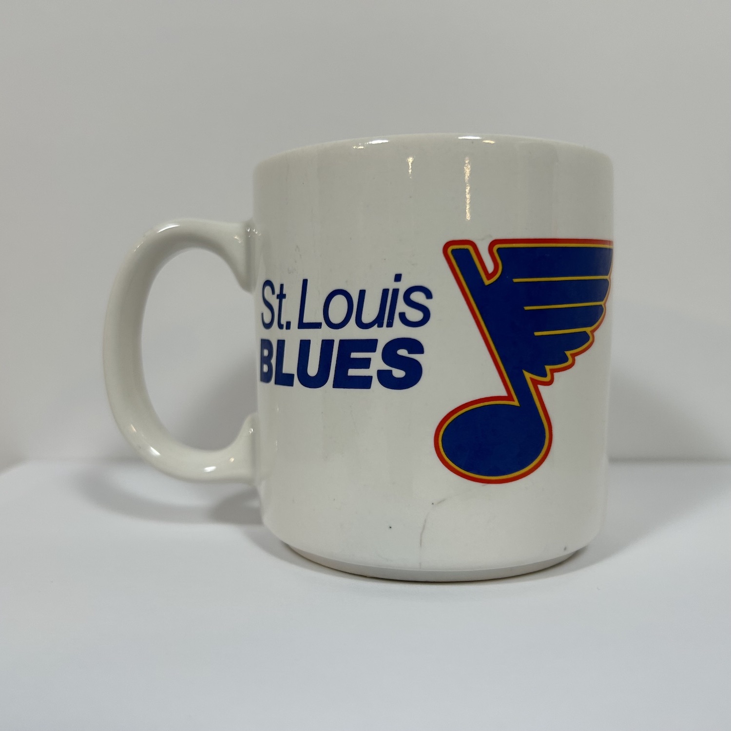 vintage white coffee mug with vintage blue, white and red St. Louis Blues Logo on front