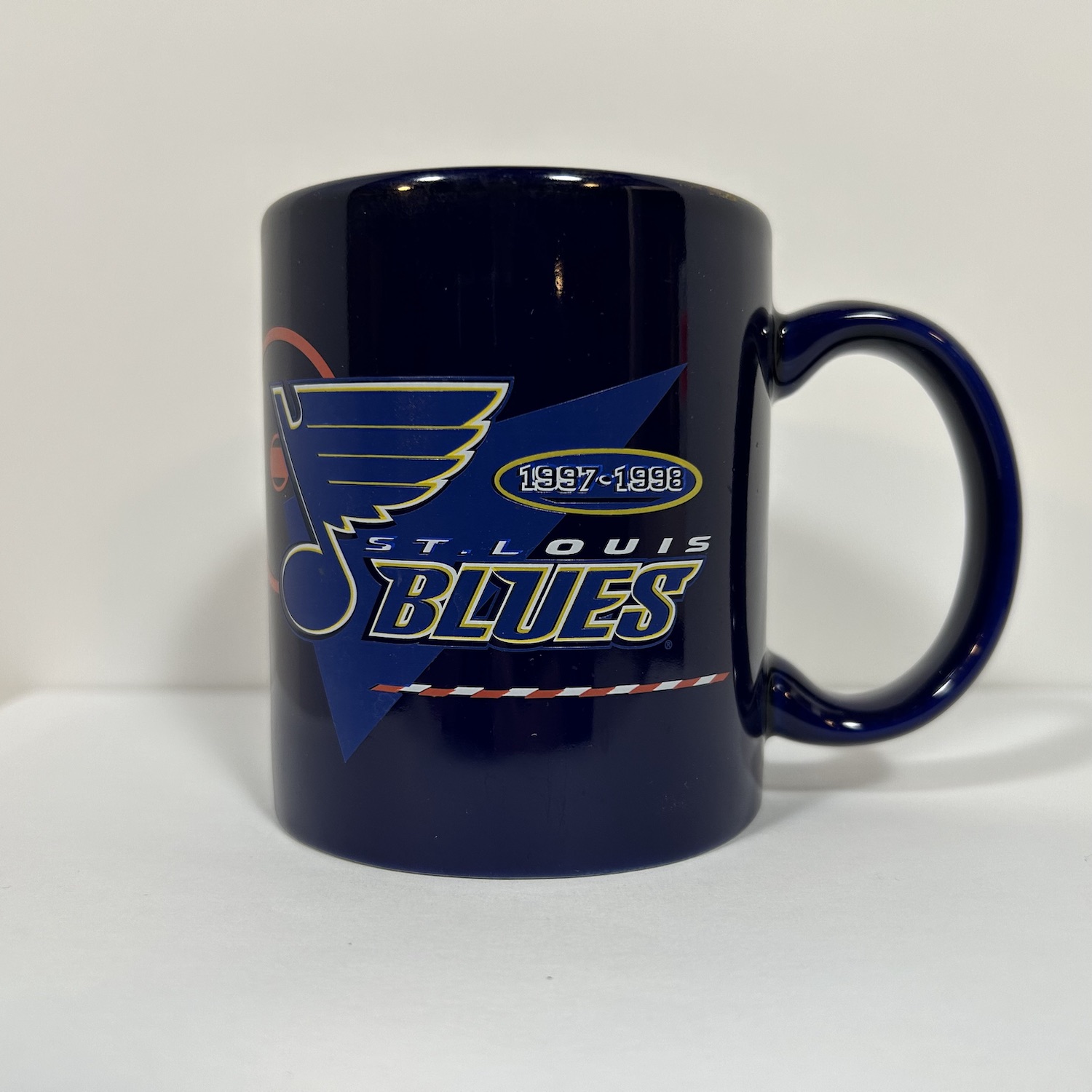 Navy coffee mug with blues logo on top of faceoff circle